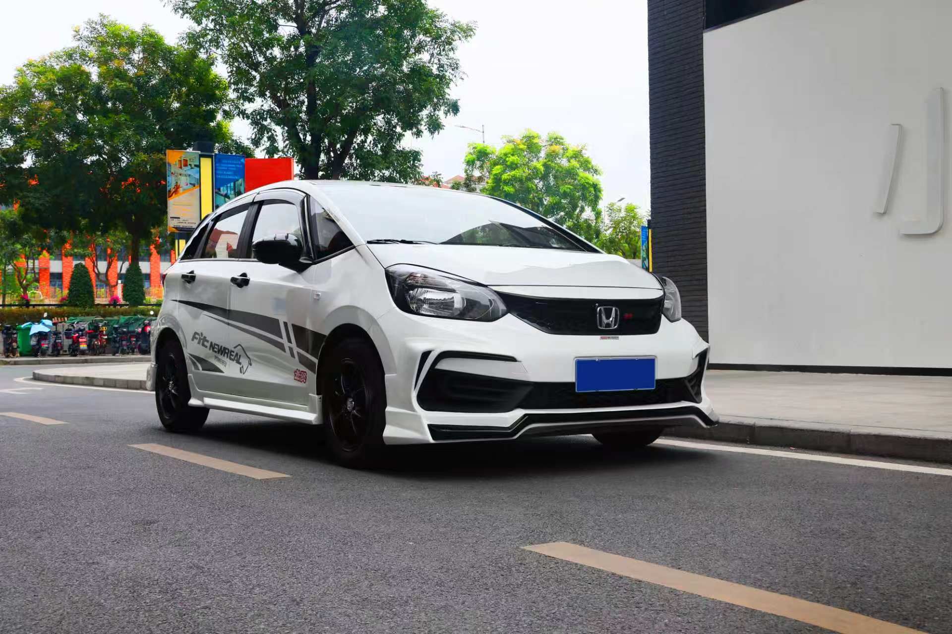 White Honda Fit shown with exterior body styling parts
